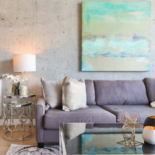 living room photo with grey couch at center that is below a large abstract art painting